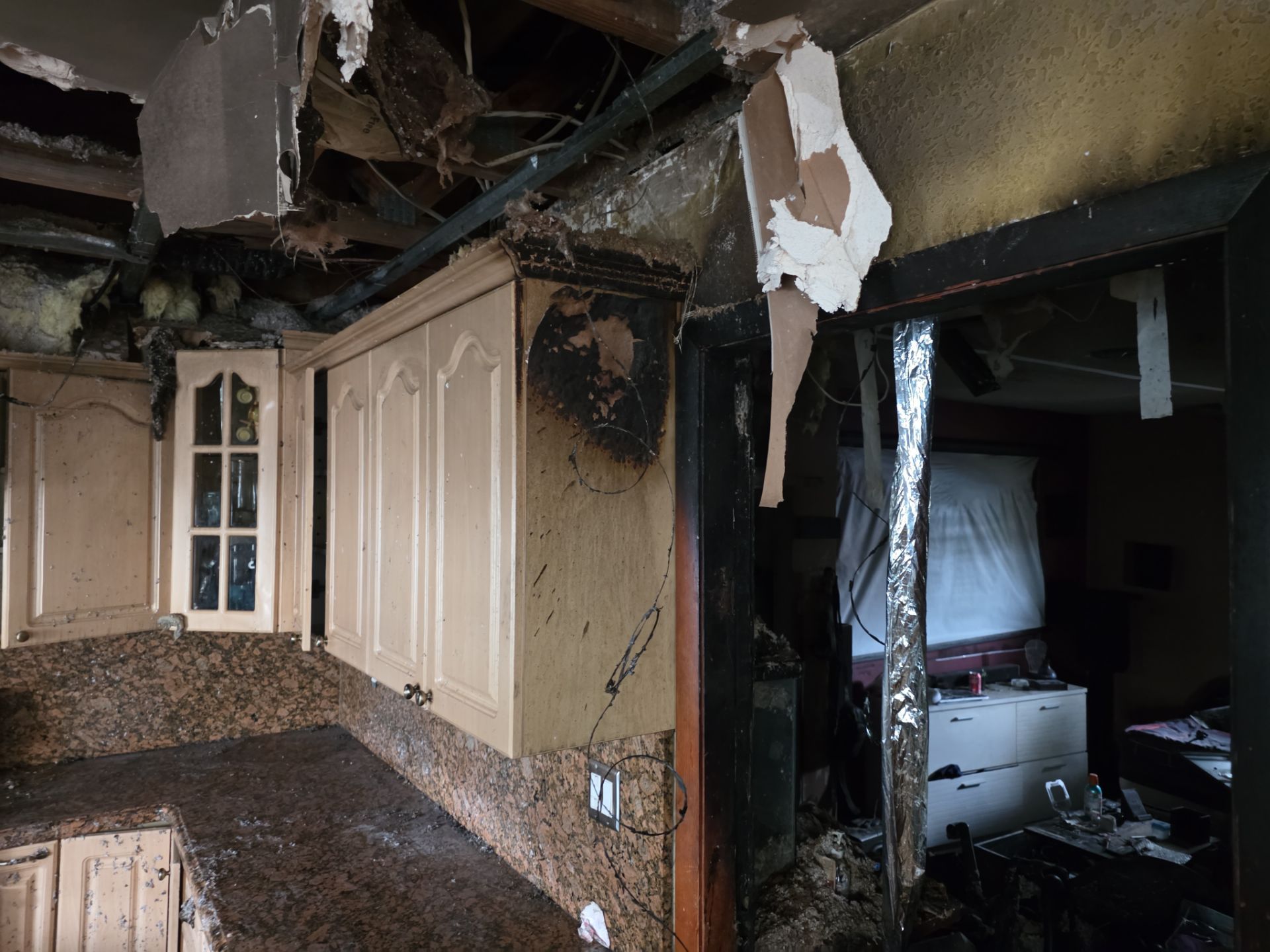 Severe fire damage to kitchen cabinets and ceiling structure